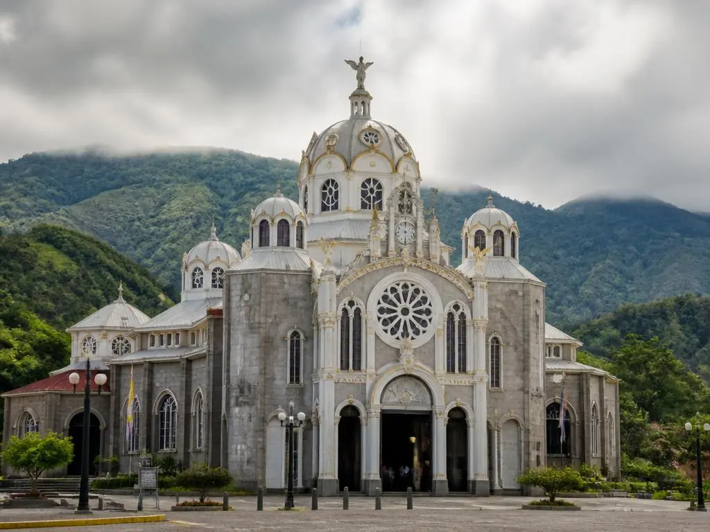 The Basilica de los Ángeles in Cartago with green mountains behind